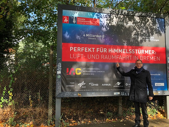 Senator Martin Günthner vor einem der knapp 600 Plakate zum Luft- und Raumfahrtstandort Bremen