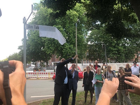Bürgermeister Andreas  Bovenschulte enthüllt das neue Straßenschild "Am Tabakquartier"