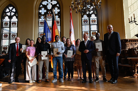 29. Einbürgerungsfeier im Bremer Rathaus: Die neu eingebürgerten Bremerinnen und Bremer mit Bundeskanzler Olaf Scholz (4. v. re.), Bürgermeister Andreas Bovenschulte (re.) und Innensenator Ulrich Mäurer (li.). Foto: Senatspressestelleen neu eingebürgerten Menschen