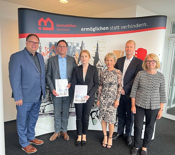 Nach der Vertragsunterzeichnung für den Neubau der Ganztagsschule am Alten Postweg (von links): Finanzsenator Björn Fecker; Carsten Hense (Geschäftsführer Goldbeck Public Partner GmbH); Susanne Kirchmann (Geschäftsführerin Immobilien Bremen); Kerstin Brockmüller (Abteilungsleiterin Projektsteuerung bei IB); Tim Heinemann (PD – Berater der öffentlichen Hand GmbH) und Regine Dohle (Geschäftsführerin Dohle+Lohse_Architekten). Foto: Immobilien Bremen/Cecere