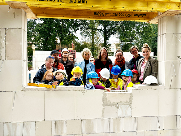 Die Kinder durften ihre Wünsche für das KuFZ, zusammen mit der Kinder- und Bildungssenatorin, Sascha Aulepp (Mitte), Kerstin Brockmüller von Immobilien Bremen (rechts daneben), Susanne Rubin-Tänzer, die ehemalige Kita-Leitung des KuFZ Arbergen (links daneben),  Petra Zschüntzsch, stv. Geschäftsführung, Pädagogische Leitung von KiTa Bremen und weitere pädagogische Fachkräfte und Vertreterinnen und Vertreter. Foto: Katharina Hebecker 