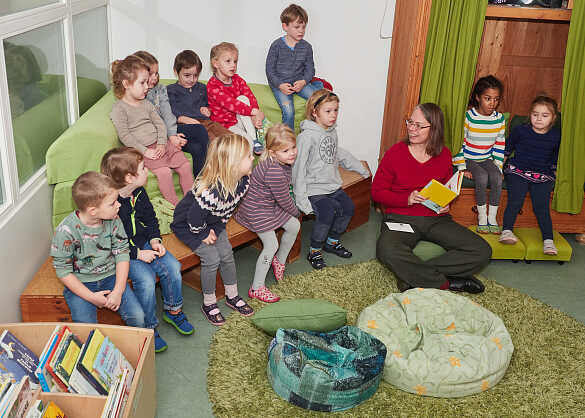 Besuch im KuFZ Bei den drei Pfählen: Die Senatorin fesselt die Kinder mit einer Vorlesestunde und sorgt für strahlende Gesichter und gespannte Aufmerksamkeit.